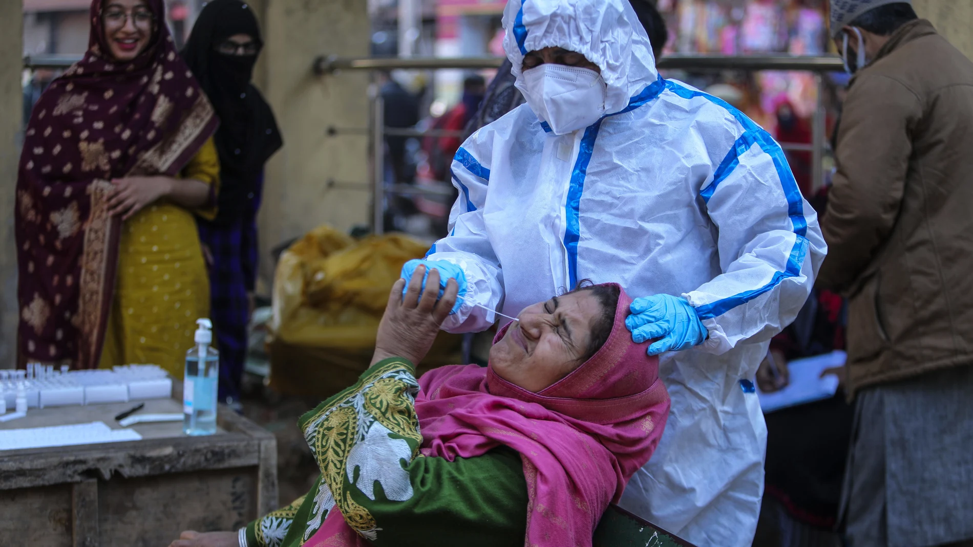 Un sanitario hace una prueba covid a una mujer en Jammu, la India