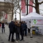 La gente se acerca a un puesto de test de antígenos en los Campos Elíseos de París