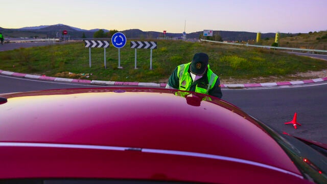 Un agente detiene a un coche durante un control de la Guardia Civil.