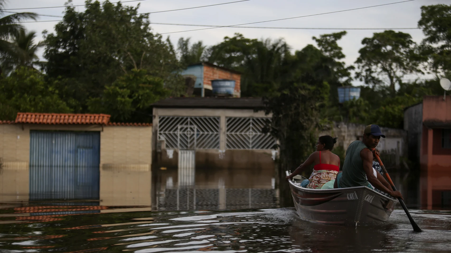 Luzia Barbosa de Oliveira, not pictured, accompanied by family members, is transported on a boat to her home partially submerged by flood waters in Sambaituba, a rural area of Ilheus, Bahia state, Brazil, Dec. 29, 2021. Over 100 cities in the northeastern Brazilian state of Bahia are in a state of emergency because of flooding due to heavy rains that have been pounding the region since the end of November. (AP Photo/Raphael Muller)