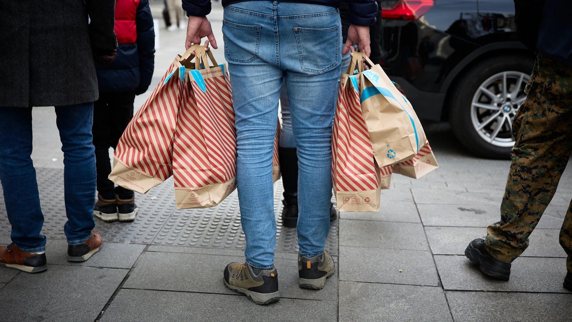 Una persona con bolsas en una calle comercial
