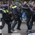 Miembros de las fuerzas de seguridad se enfrentan a unos manifestantes en la protesta de hoy contra las medidas del coronavirus en Ámsterdam