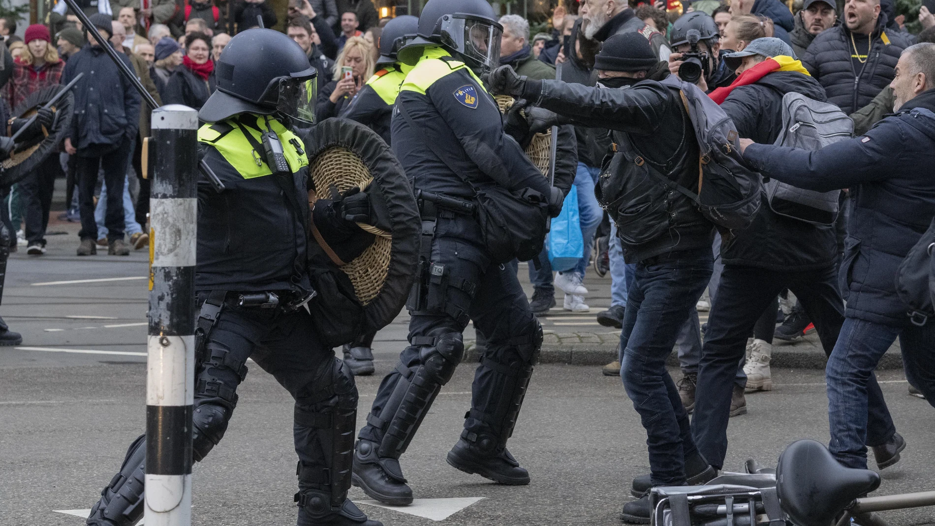 Miembros de las fuerzas de seguridad se enfrentan a unos manifestantes en la protesta de hoy contra las medidas del coronavirus en Ámsterdam