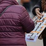 Una mujer compra un décimo de lotería a una vendedora ambulante, tres días antes del Sorteo de La Lotería del Niño, a 3 de enero de 2022, en Madrid, (España)