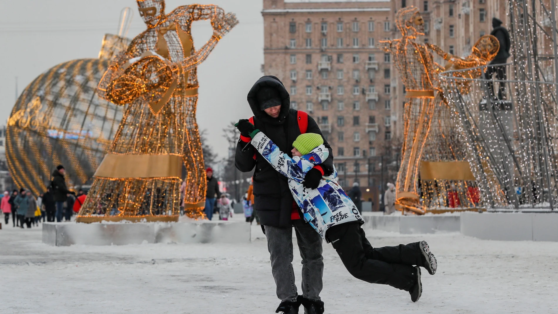 Un hombre juega con su hijo en una calle decorada con motivos navideños este martes en Moscú.