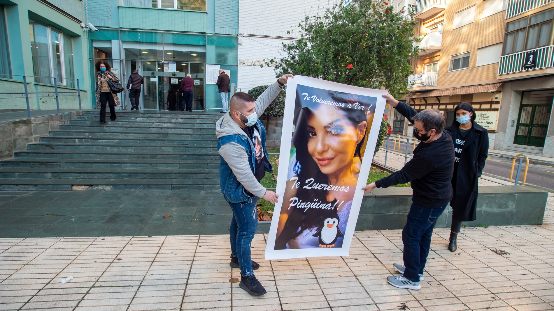 Familiares de Sara Gómez, fallecida tras someterse a una lipoescultura, despliegan un cartel con la imagen de la joven a las puertas de los juzgados de Cartagena, Murcia (España).