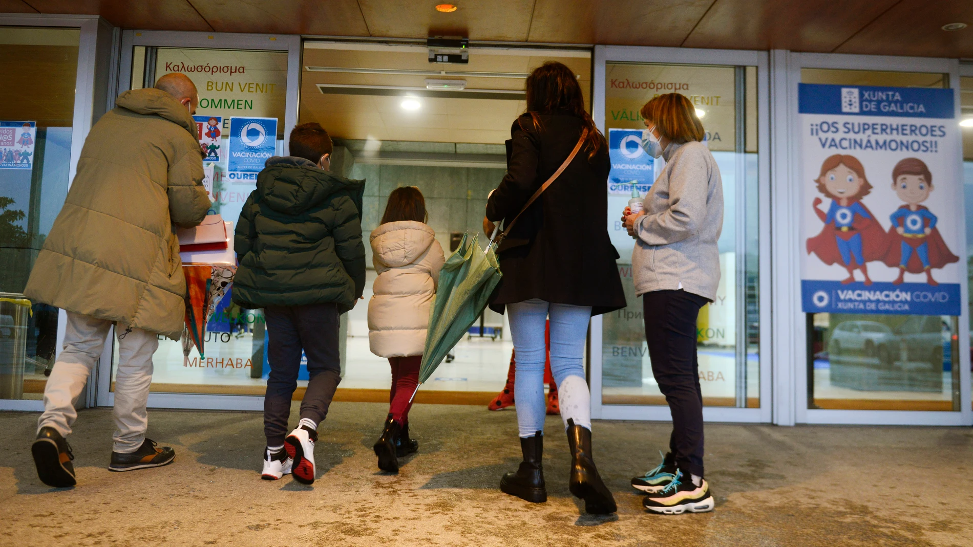 Varios niños acompañados de sus padres, a su llegada al recinto ferial Expourense (Galicia) para ser vacunados