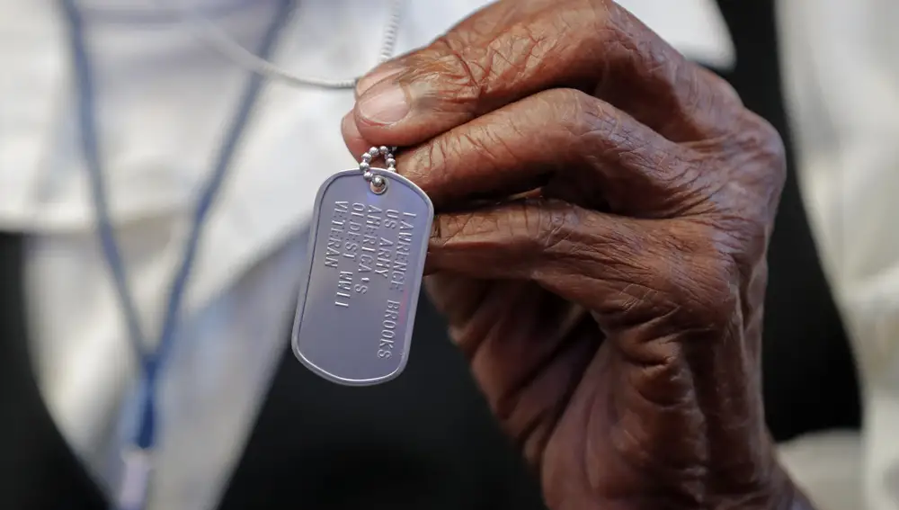 Lawrence Brooks muestra una placa de identidad que le identifica como el veterano de la Segunda Guerra Mundial más anciano