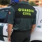 Un agente de la Guardia Civil junto a su vehículo