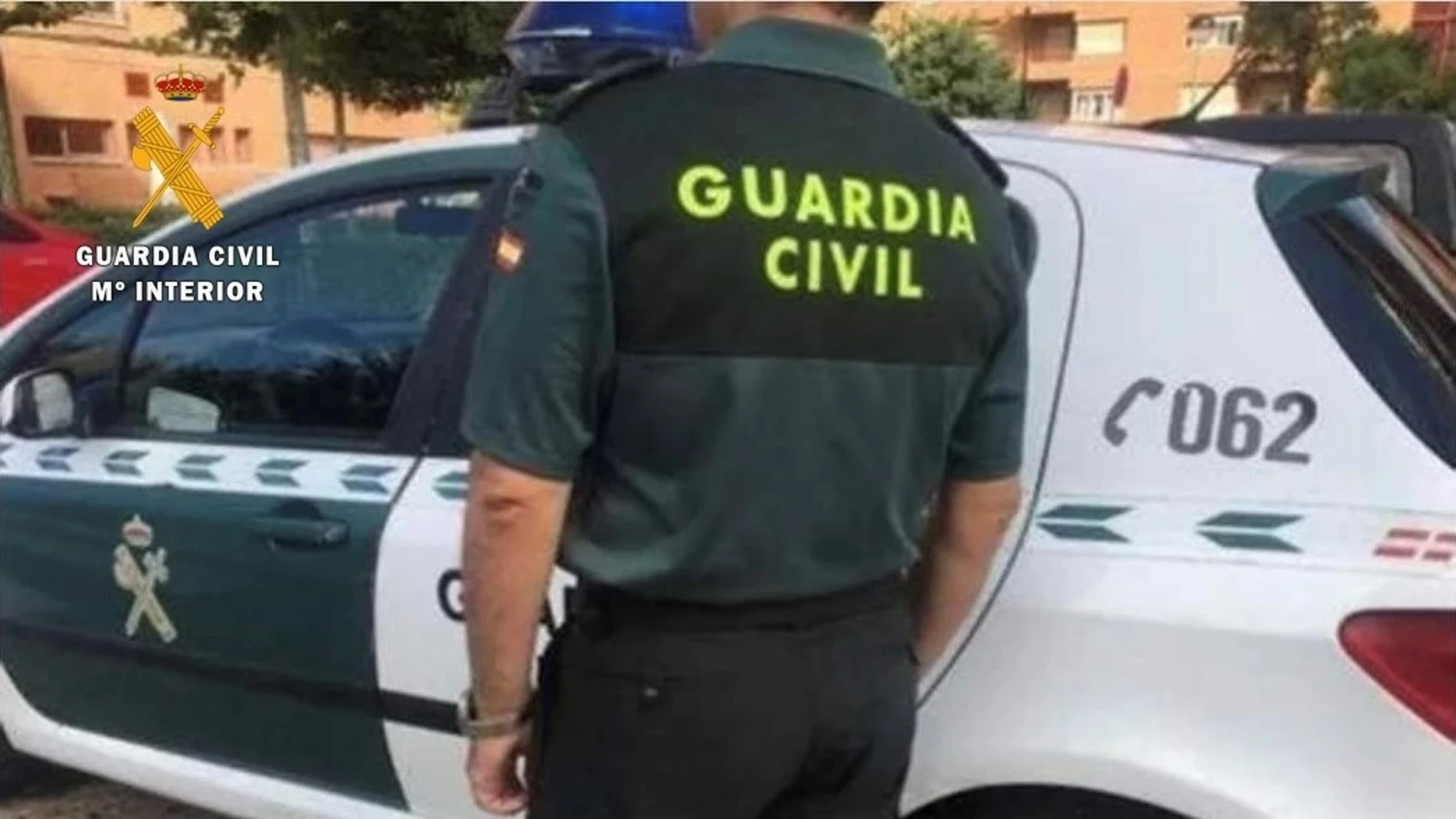 Un agente de la Guardia Civil junto a su vehículo