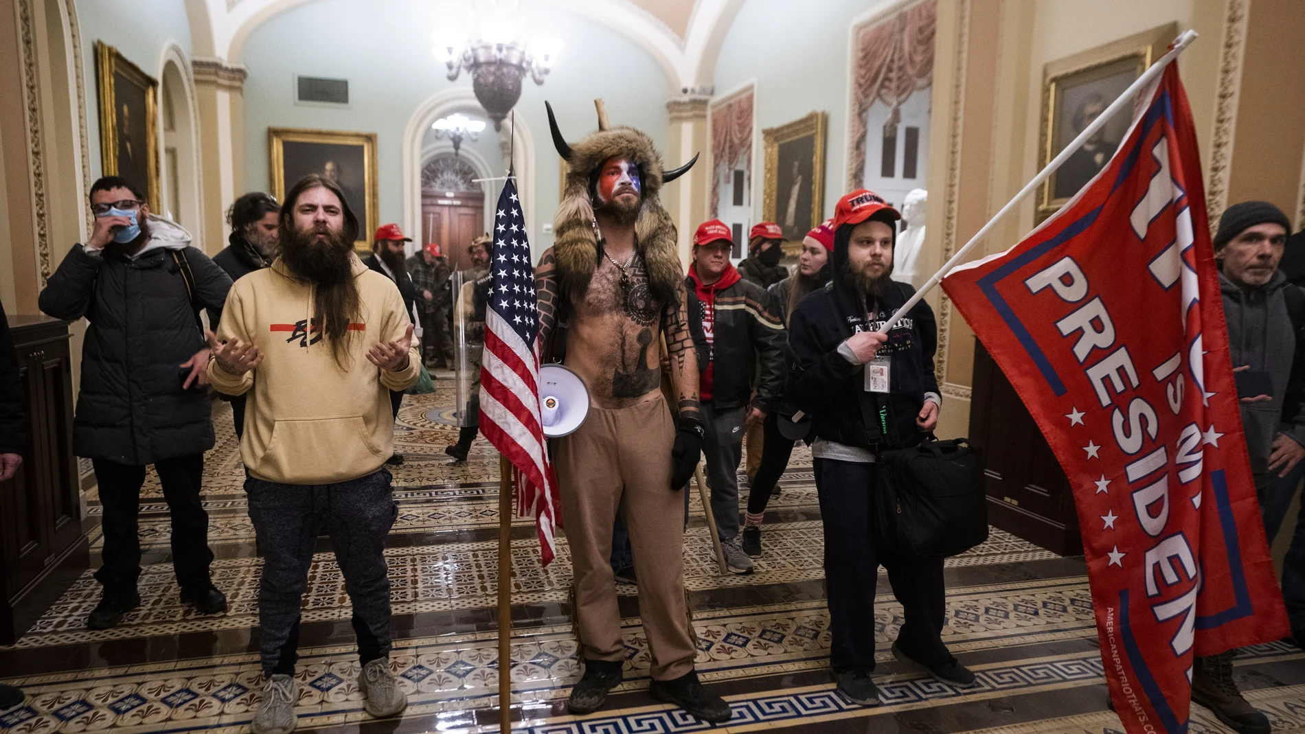 Partidarios del presidente estadounidense Trump permanecen junto a la puerta de las cámaras del Senado después de haber violado la seguridad del Capitolio de Estados Unidos en Washington, DC
