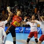 El jugador español Joan Cañellas (c) intenta un lanzamiento ante varios rivales polacos durante el partido de balonmano entre España y Polonia