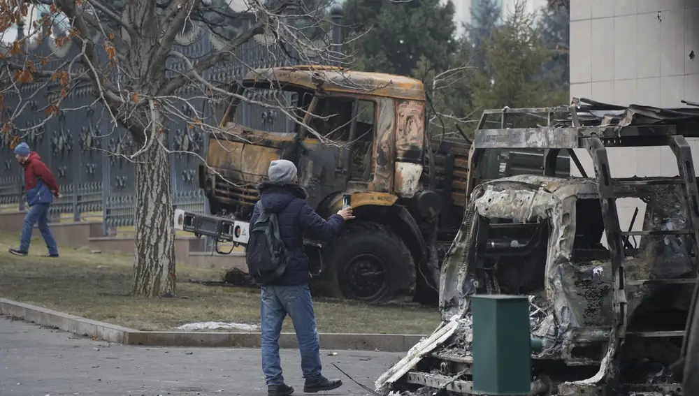 Un hombre fotografía un autobús calcinado en Almaty, Kazajistán, tras las protestas ocurridas en 1 de enero.