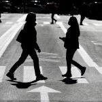 Dos personas con mascarilla se cruzan en una calle de la ciudad de Valencia