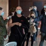 Una enfermera capitán del ejército de tierra administra la tercera dosis de la vacuna de Moderna contra el Covid 19 a un hombre