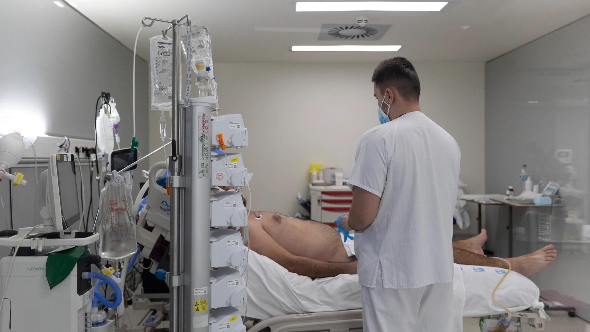 Un sanitario atiende a un paciente ingresado en la UCI del Hospital Isabel Zendal de Madrid
