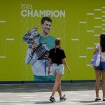 Dos aficionadas pasan por delante de una imagen de Djokovic en el Melbourne Park
