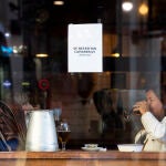 Imagen del escaparte de un bar en el que cuelga un cartel que reza "Se necesitan camareros".
