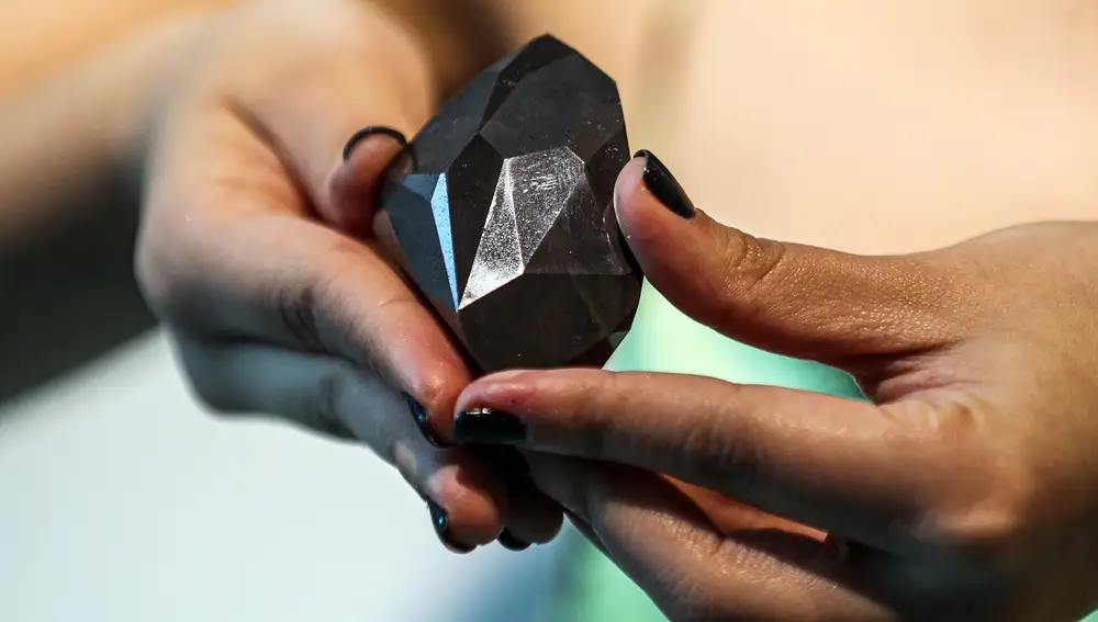 Un empleado de Sotheby's Dubái presenta el diamante negro de 555,55 quilates 'Enigma' durante la inauguración mundial de la subasta | Fuente: EFE/EPA/ALI HAIDER