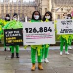 Un grupo de activistas pide que las vacunas lleguen al Tercer Mundo en la plaza del Parlamento británico, en Londres