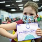 Hugo, de seis años, posa con su certificado de vacunación en la Expo de Namur, en Bélgica