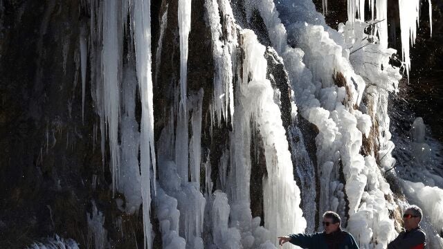 Dos personas junto a una cascada de hielo cercana a la localidad de Roncal formada tras las temperaturas bajo cero que durante varios días se llevan produciendo en Navarra