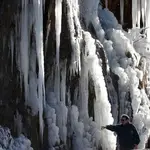Dos personas junto a una cascada de hielo cercana a la localidad de Roncal formada tras las temperaturas bajo cero que durante varios días se llevan produciendo en Navarra