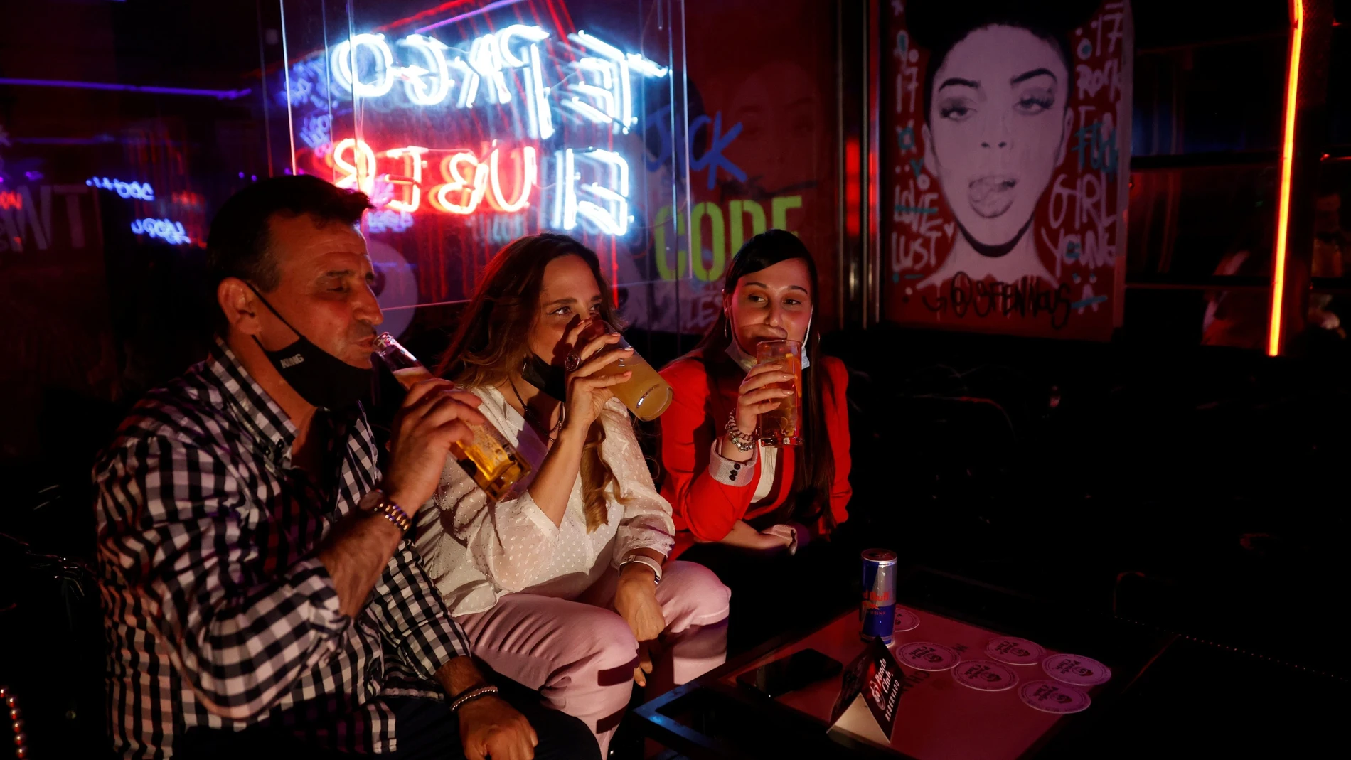 Tres personas toman consumiciones en el interior de una discoteca en Madrid. Los locales de ocio nocturno (bares de copas y discotecas) reabren en la Comunidad de Madrid