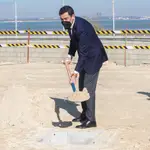 El presidente de la Junta de Andalucía, Juanma Moreno, echa tierra durante el acto donde de colocación de la primera piedra de la nueva Estación Depuradora de Aguas Residuales (EDAR) de Puerto Real (Cádiz). EFE/Román Ríos.