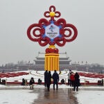 24 January 2022, China, Beijing: A group of people stand in front of a decoration for the 2022 Beijing Winter Olympics on display in Tiananmen Square. The Beijing Winter Olympics will take place from 04 to 20 February. Photo: Yan Xiang/SIPA Asia via ZUMA Press Wire/dpa Yan Xiang/SIPA Asia via ZUMA Pre / DPA 24/01/2022 ONLY FOR USE IN SPAIN