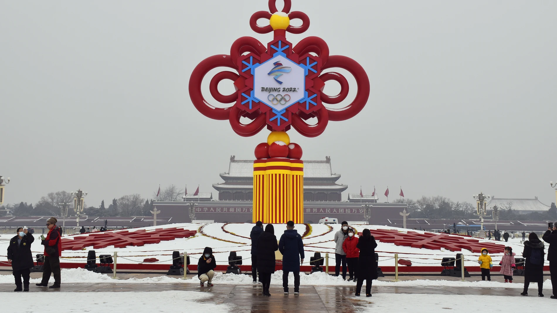 24 January 2022, China, Beijing: A group of people stand in front of a decoration for the 2022 Beijing Winter Olympics on display in Tiananmen Square. The Beijing Winter Olympics will take place from 04 to 20 February. Photo: Yan Xiang/SIPA Asia via ZUMA Press Wire/dpa Yan Xiang/SIPA Asia via ZUMA Pre / DPA 24/01/2022 ONLY FOR USE IN SPAIN
