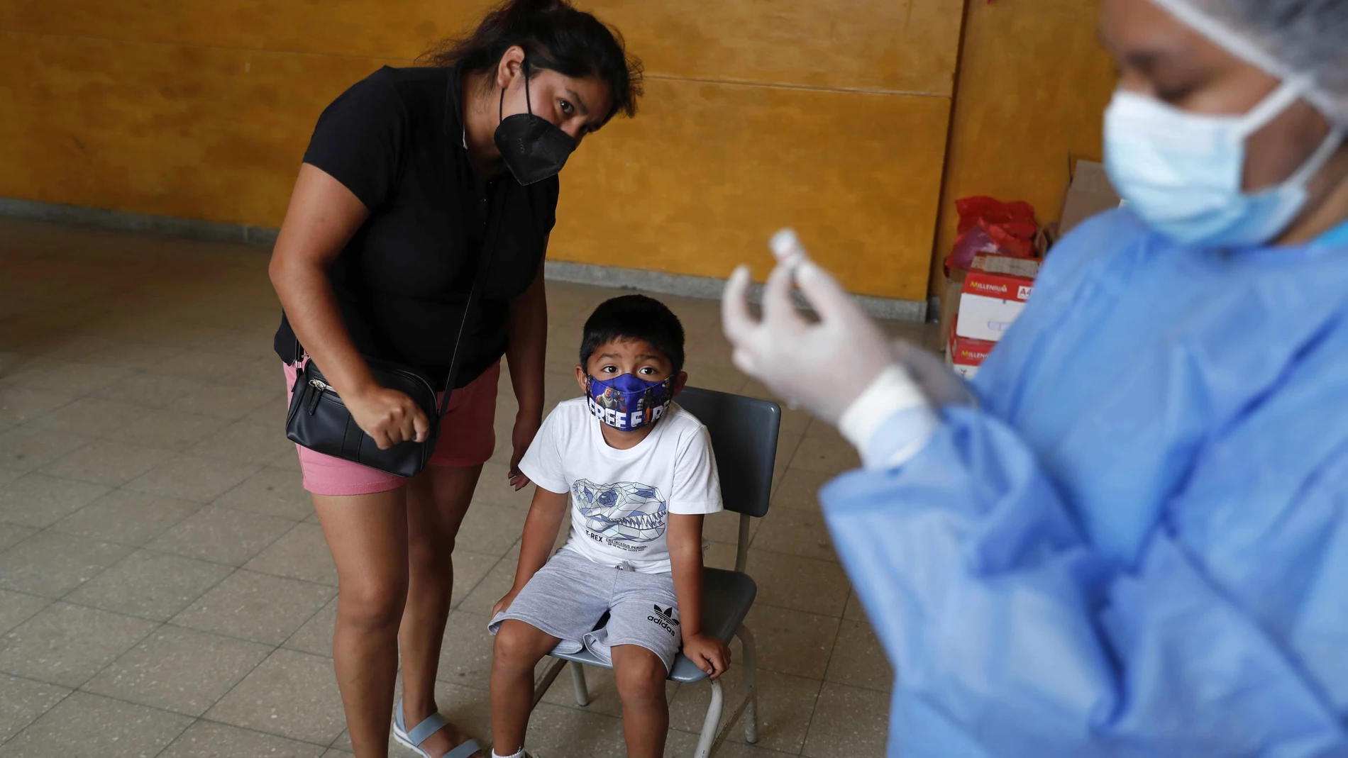 Un niño espera para recibir una vacuna contra la covid-19 hoy, en el colegio público Ricardo Bentín, en Lima (Perú)