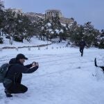 Un hombre hace una foto con la Acrópolis al fondo