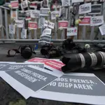 Foto de Archivo: Fotografía de carteles, flores, retratos y cámaras fotográficas en el suelo como acto de protesta por los asesinatos a periodistas