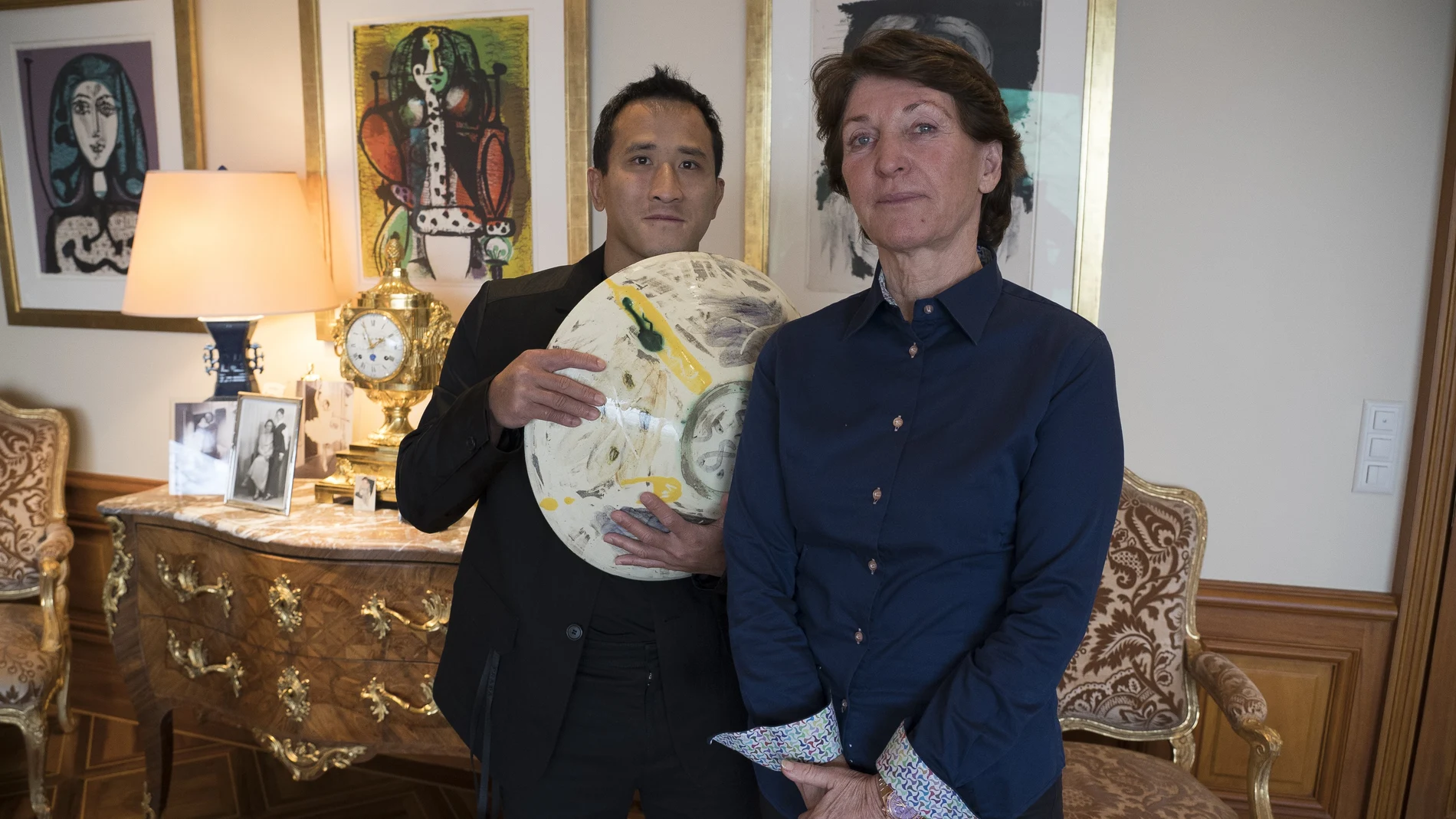 Marina Picasso, nieta del artista Pablo Picasso, y su hijo Florian Picasso posan con una obra de arte de cerámica de Pablo Picasso en Ginebra.