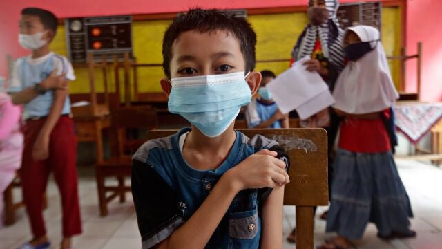 Un niño se sujeta el hombro poco después de recibir la dosis de la vacuna contra la Covid-19 en una escuela primaria de Tangerang, Indonesia