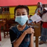 Un niño se sujeta el hombro poco después de recibir la dosis de la vacuna contra la Covid-19 en una escuela primaria de Tangerang, Indonesia