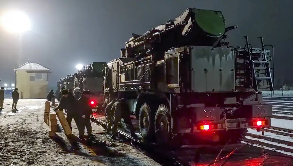 Vehículos militares rusos se preparan para salir de una plataforma ferroviaria después de llegar a Bielorrusia.