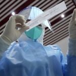 Un sanitario se prepara para tomar una muestra de hisopo para una prueba de COVID-19 en el Aeropuerto Internacional de la Capital de Beijing antes de los Juegos Olímpicos de Invierno de 2022