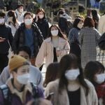 Personas con mascarillas caminan por una calle en Tokio
