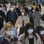 Personas con mascarillas caminan por una calle en Tokio