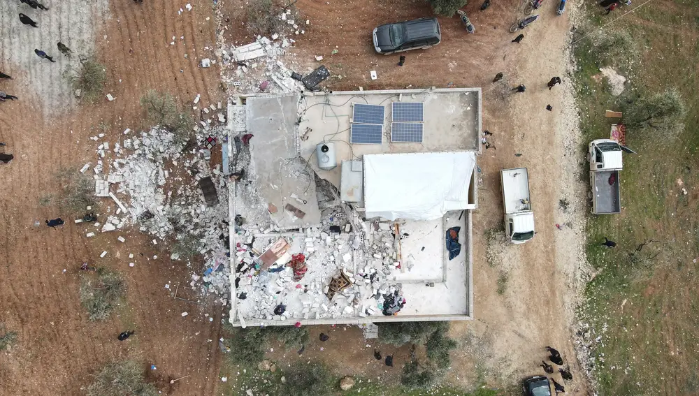 Una fotografía aérea tomada por un dron muestra a personas inspeccionando un edificio dañado en la provincia siria de Idlib tras una operación antiterrorista de las fuerzas especiales de EEUU