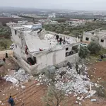 Una fotografía aérea tomada por un dron muestra a personas inspeccionando un edificio dañado tras una supuesta operación antiterrorista de las fuerzas especiales de EEUU