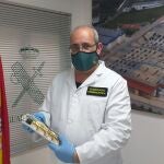 Javier Saiz, del Departamento de Investigación del Incendios del Laboratorio de Criminalística de la Guardia Civil, sostiene una regleta eléctrica y una pieza de cobre calcinada y cortocircuitada.