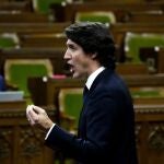 El primer ministro canadiense, Justin Trudeau, se levanta durante un debate de urgencia en la Cámara de los Comunes sobre la situación en Ottawa, mientras la protesta contra las restricciones de la COVID-19, marcada por los atascos y el sonido de las bocinas de los camiones, continúa en su segunda semana, en Ottawa