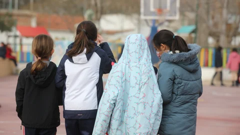 Varias niñas juegan en el recreo de un colegio de Madrid el primer día de clase presencial tras la Navidad