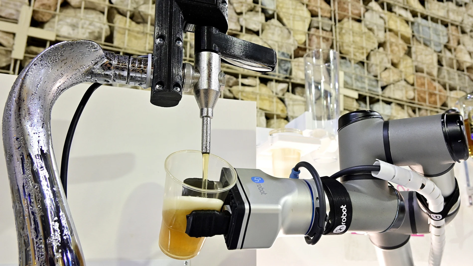 Un brazo robotizado sirve un vaso de cerveza como muestra de una de las alternativas que se ofrecen en el Salón de Innovación de la Hostelería "H&T" en Málaga. EFE / Jorge Zapata