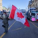 Una persona ondea una bandera de Canadá durante una manifestación y una sentada, tras una protesta de 10 días de los camioneros por las restricciones de Covid-19 que ha paralizado el centro de Ottawa (Canadá)