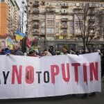 Ucranianos se manifiestan en Kiev portando una pancarta contra Vladimir Putin.