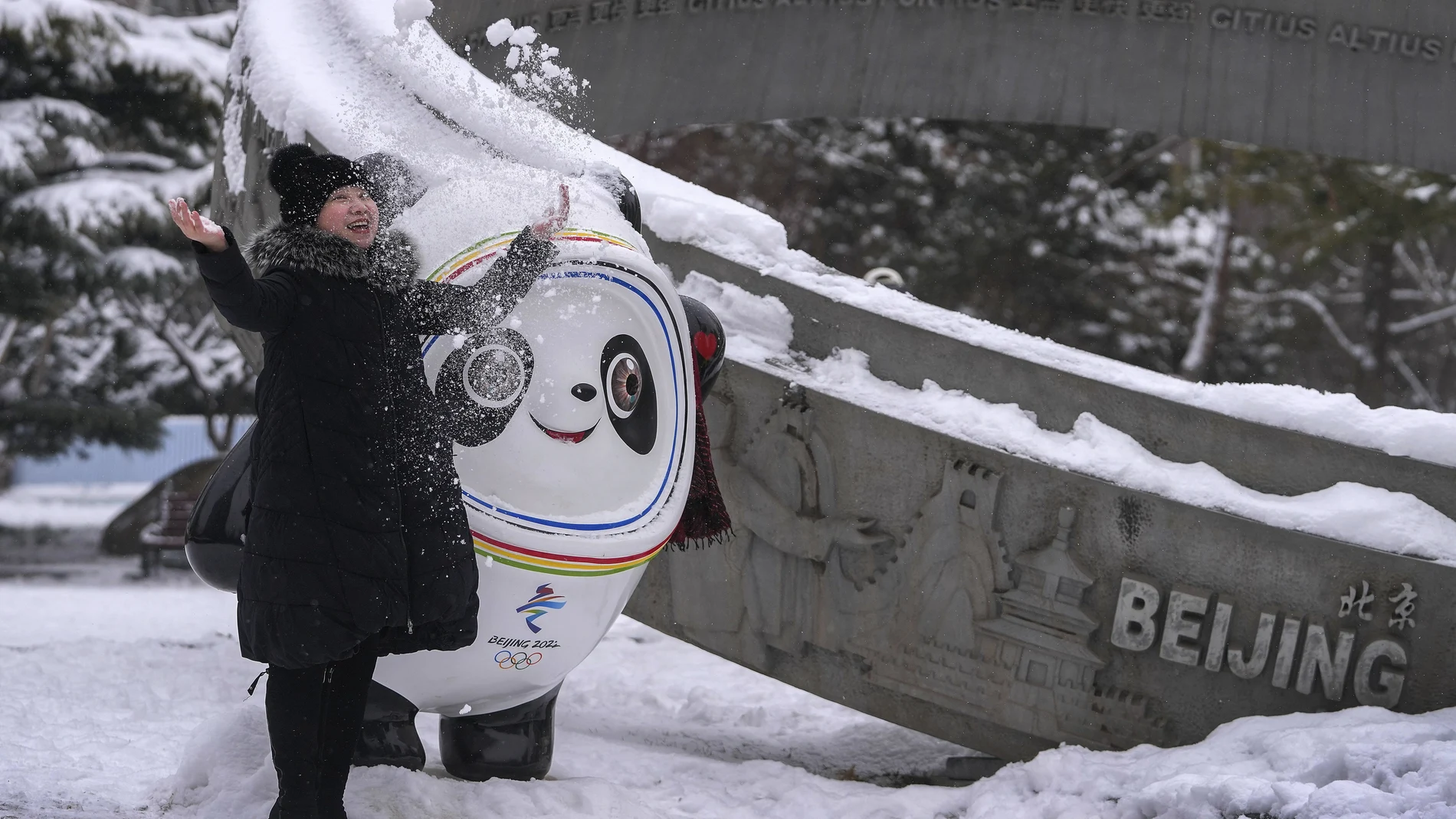 Una mujer posa junto a Bing Dwen Dwen, la mascota de los Juegos Olímpicos de Invierno